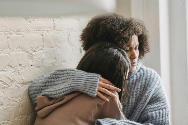 Sad women hugging at home